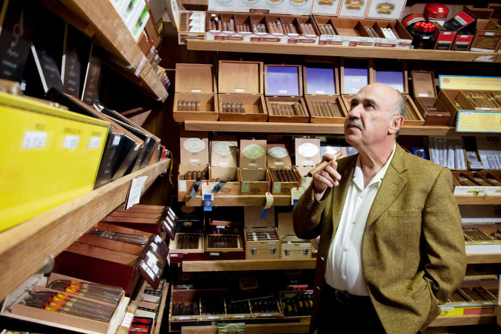 Man-contemplating-cigar-purchase